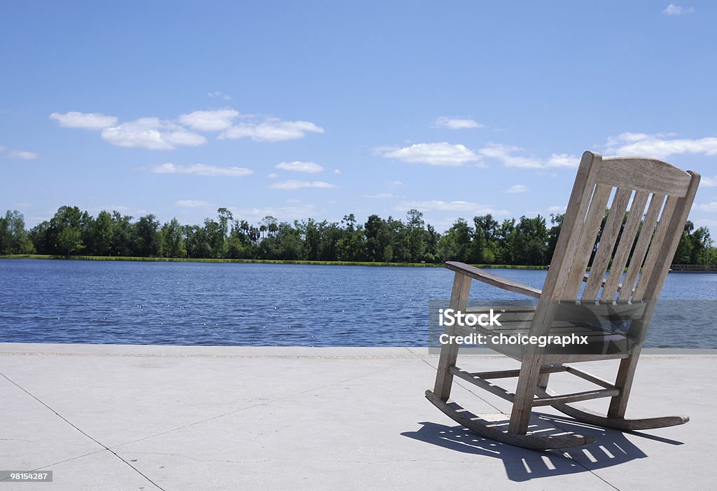 Sedia a dondolo sul lago-riposo e relax - Foto stock royalty-free di Pensionamento
