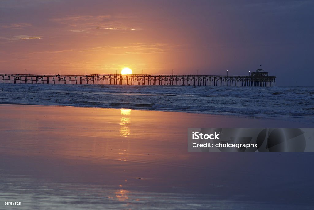 Fishing pier at sunset in Cherry Grove, Myrtle Beach Cherry Grove Fishing Pier in Myrtle Beach South Caroline at sunrise. Focus is on the pier South Carolina Stock Photo