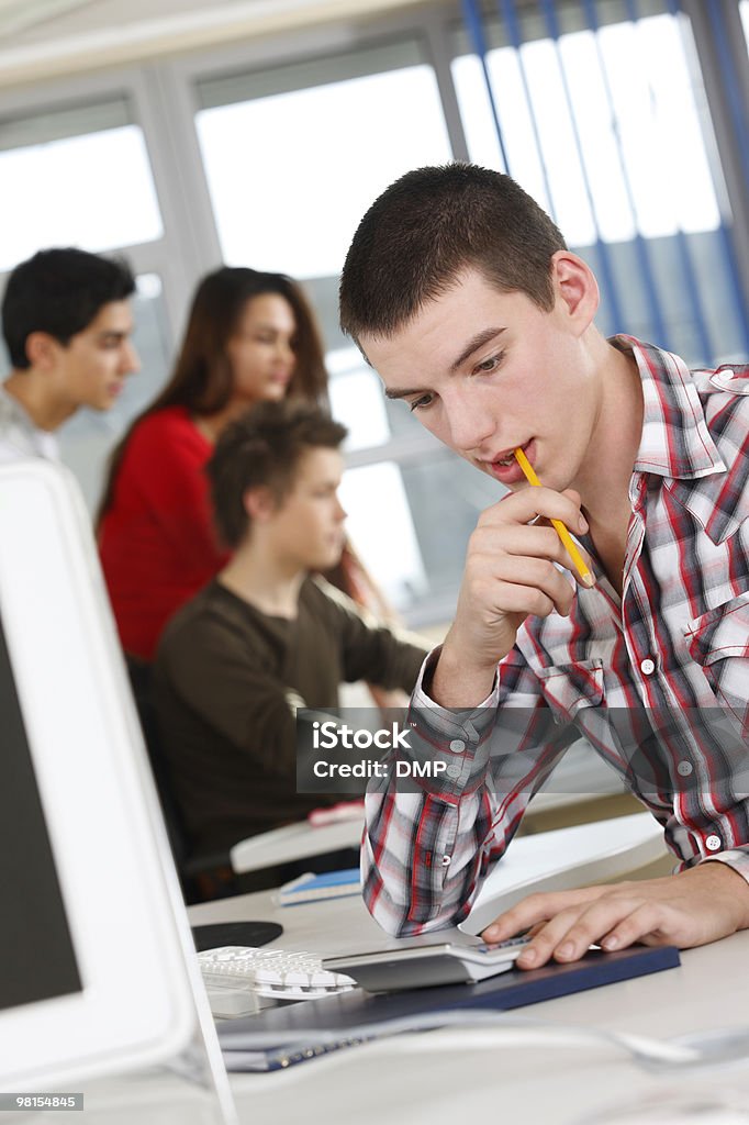 Giovane maschio studente studiare duro sul computer in university - Foto stock royalty-free di Adolescente