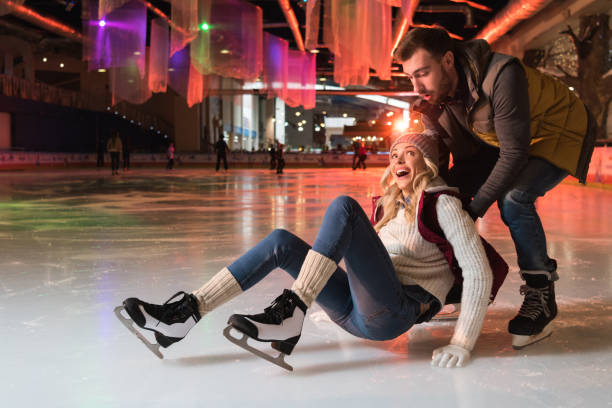 istock beautiful young couple teaching ice skating on rink 981573020
