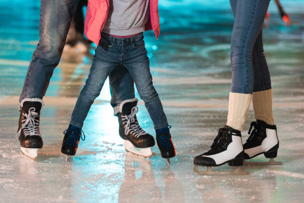 aufnahme der jungen familie in schlittschuhe zusammen auf eisbahn schlittschuh laufen beschnitten - ice winter white women stock-fotos und bilder