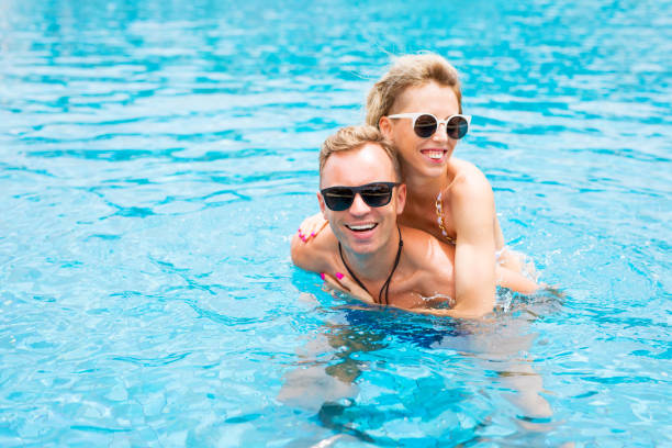istock Couple having fun in the pool 981585564