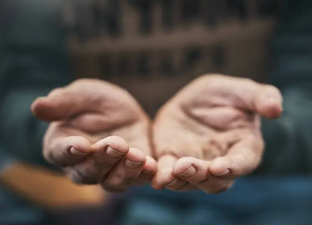 Photo of Beggar holding out his hands in appeal