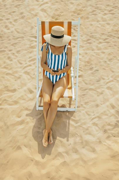 giovane donna sulla spiaggia italiana - sensuality people mobile phone 30s foto e immagini stock