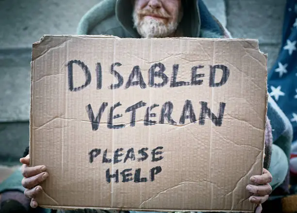 Photo of Destitute man with sign 