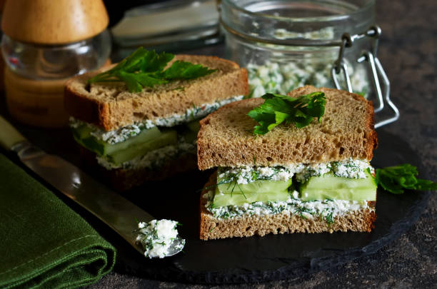 istock Vegan sandwich with cheese, cucumber and spices on a dark background. 981605638