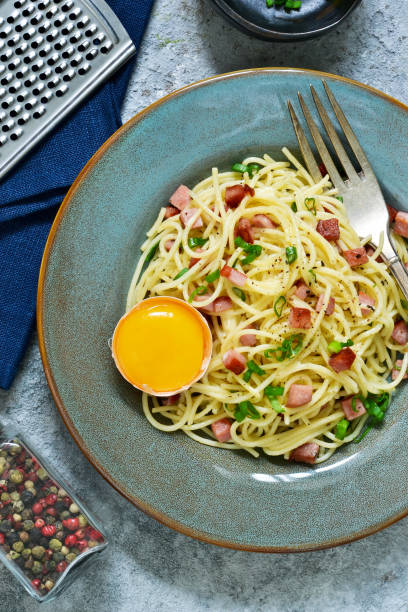 pâte carbonara. spaghetti aux lardons, parmesan et œufs. - lard close up pasta eggs photos et images de collection