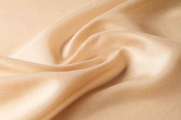 istock Texture background of fabric. Beige fabric. Silk fabric wallpaper texture background pattern in sepia pastel yellow cream beige tint: Lovely natural silk textured textile 981605720