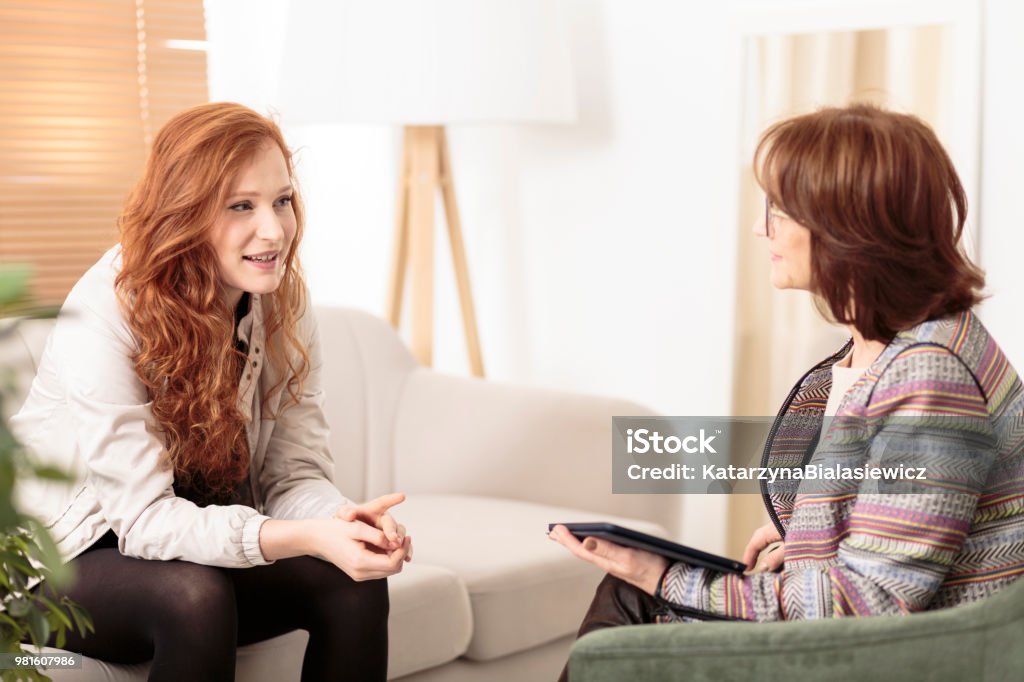 Friendly therapist supporting red-haired woman Friendly therapist supporting red-haired woman how to manage health and life goals Mental Health Professional Stock Photo