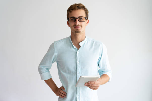 istock Positive confident young male manager in glasses using tablet 981613106