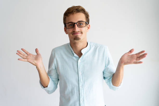 istock Smiling careless blonde guy showing do not know gesture 981615738