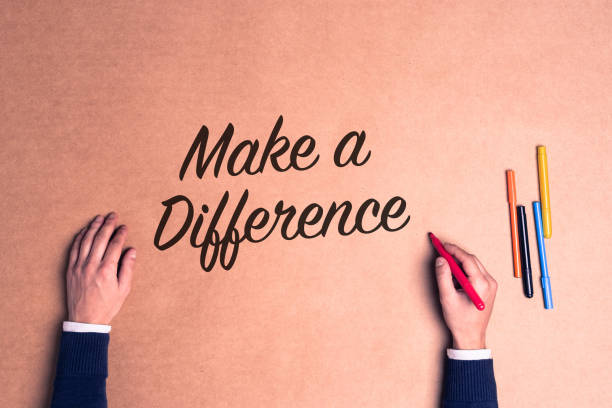 Hand writing a phrase Make a Difference on paper stock photo