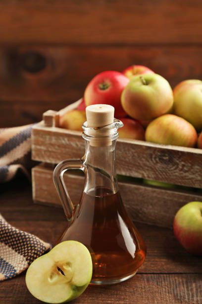 istock Apple vinegar in glass bottle on brown wooden table 981626064