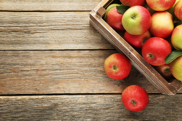 istock Ripe apples in crate on grey wooden table 981626618