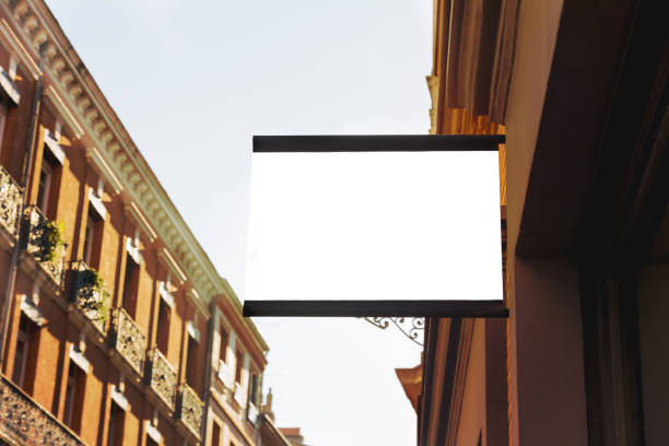istock Blank round signboard, hanging from the facade of a building 981626734
