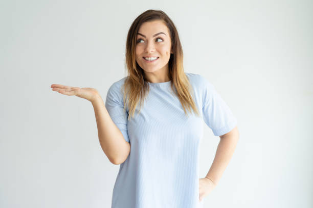 istock Smiling beautiful woman holding empty space on palm 981626832