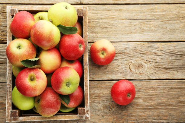 istock Ripe apples in crate on grey wooden table 981627760