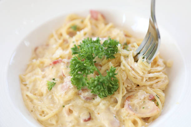 istock Spaghetti white sauce (Spaghetti Carbonara) with bacon and garlic , on wood table background 981634070