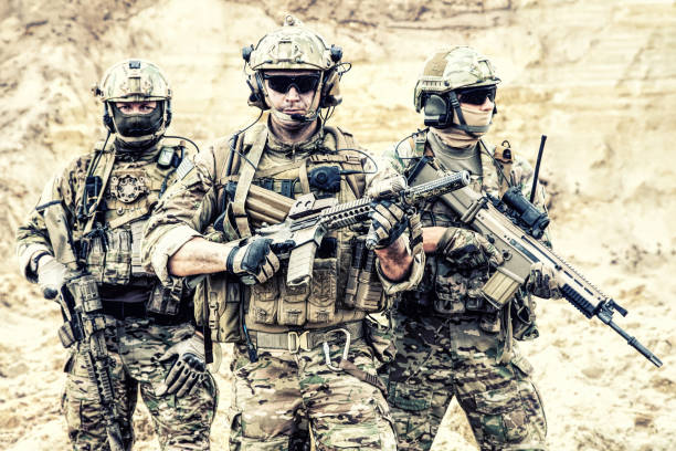 Equipped elite forces soldiers in combat readiness Group portrait of US army elite members, private military company servicemen, anti terrorist squad fighters standing together with guns. Brothers in arms, war conflict combatants, soldiers of fortune special forces photos stock pictures, royalty-free photos & images