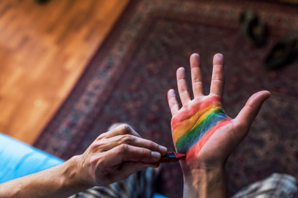 istock Man painting colored flag on hand 981641784