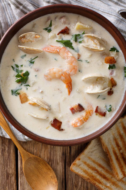 istock New England clam chowder soup close-up. Vertical top view 981643496