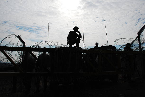 silhouette militaire - barbed wire photos photos et images de collection