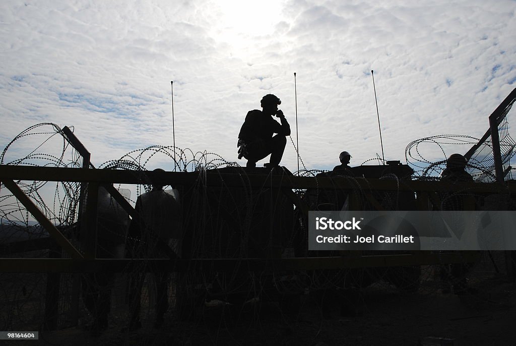 Military Silhouette Israeli soldiers guarding a barrier, silhouetted against afternoon sun Military Stock Photo