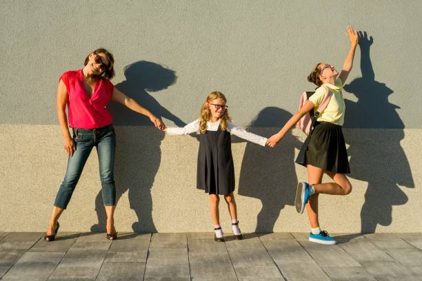 istock Mother and daughter students holding hands go to school. 981650970