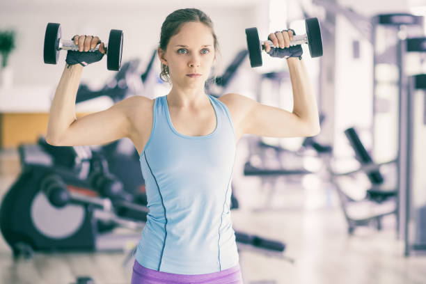 istock Serious Woman Training With Dumbbells in Gym 981651388