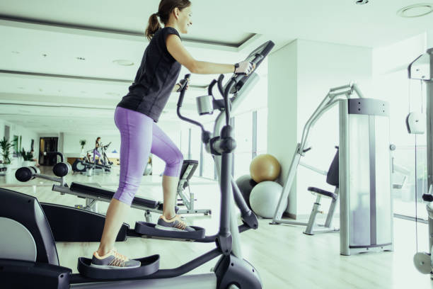 istock Smiling Girl Training on Stair Stepper in Gym 981651496