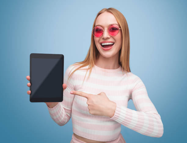 istock Woman showing tablet standing in studio 981652978
