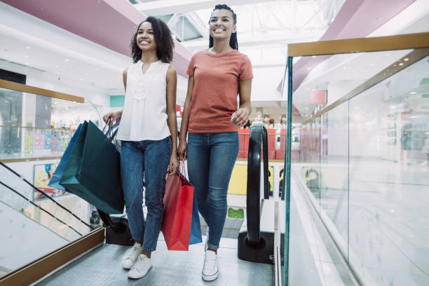 istock Two Happy Black Girls on Escalator in Mall 981663502