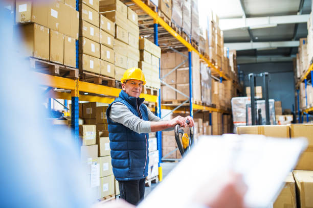 istock Senior woman manager and man worker working in a warehouse. 981667700