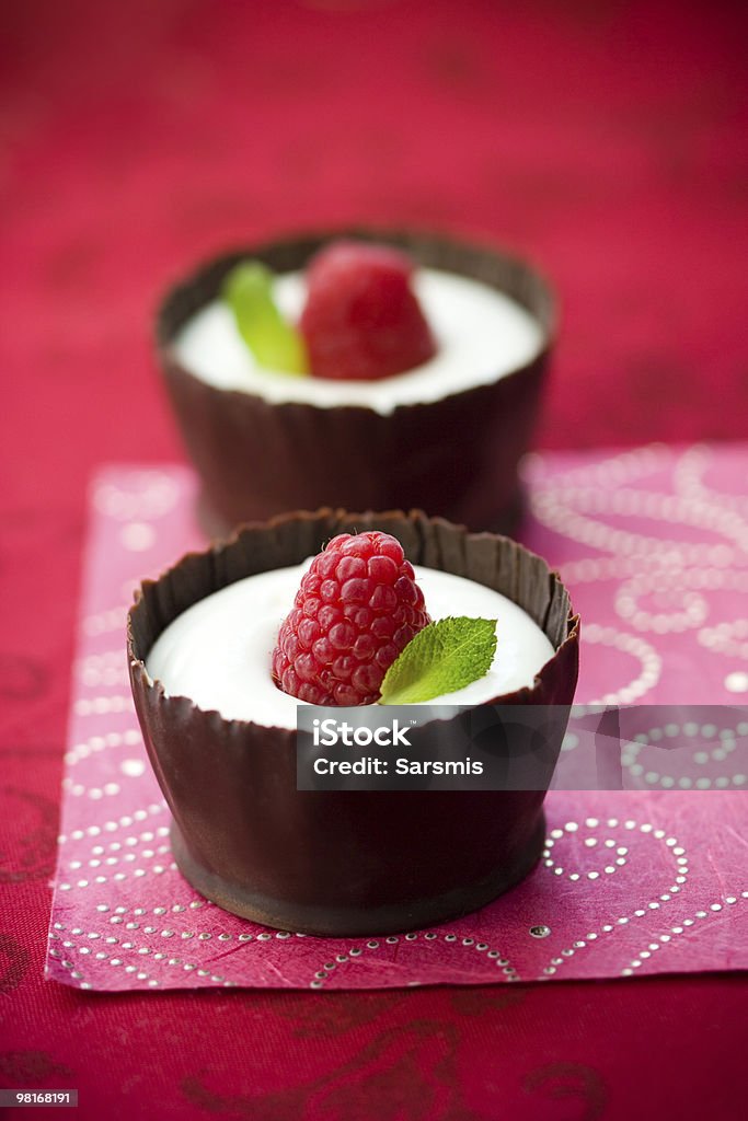 chocolate mousse with raspberry white chocolate mousse dessert served with fresh raspberry and mint in an edible chocolate cup Mousse - Dessert Stock Photo