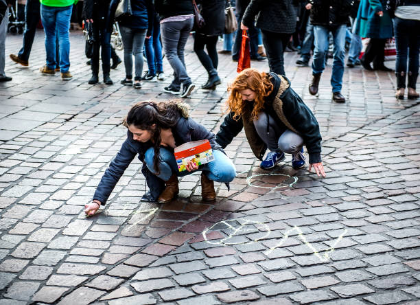 No War Trier, Germany- December 8, 2015- Two activist women writing on a asphalt No War. People against a War, Conceptual photo. Demonstration of peace. Anti-Terrorism Day stock pictures, royalty-free photos & images