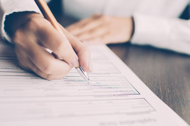 istock Female employee filling application form at table 981710724