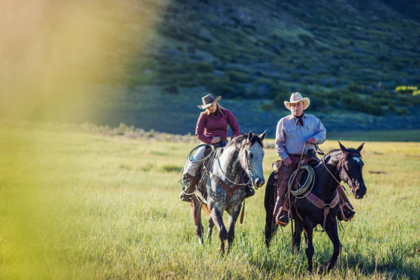 istock Old cowboy talking to his daughter while riding horses 981727712