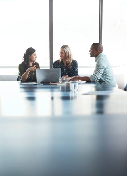 triple the expertise in this boardroom Shot of a group of businesspeople having a meeting in the boardroom of a modern office employee engagement photos stock pictures, royalty-free photos & images