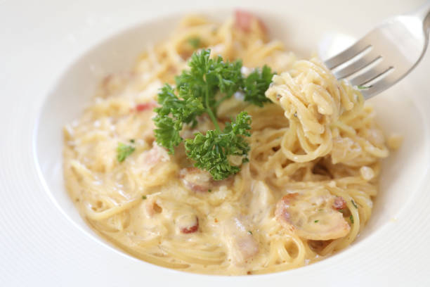 istock Spaghetti white sauce (Spaghetti Carbonara) with bacon and garlic , on wood table background 981740060