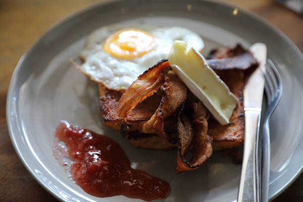 istock Breakfast french toast with bacon egg and cheese with jam on wood table background 981740112