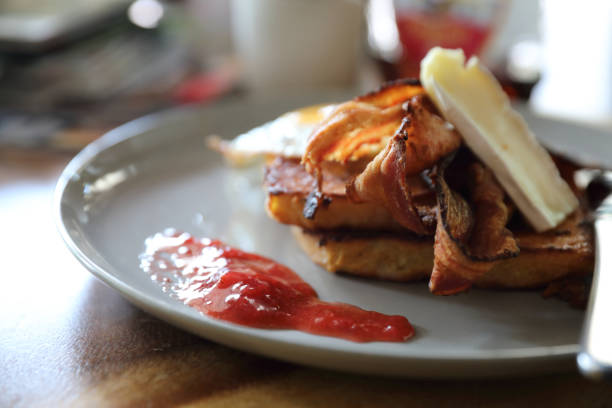 istock Breakfast french toast with bacon egg and cheese with jam on wood table background 981740534