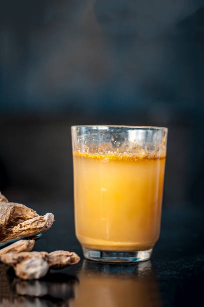 istock Dried ginger or Zingiber officinale or Soth,Sonth with ayurvedic medicinal extracted juice in a transparent glass on wooden surface improves the digestion and decreases the chances of cancer,diabetes. 981753830