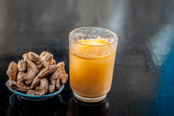 istock Dried ginger or Zingiber officinale or Soth,Sonth with ayurvedic medicinal extracted juice in a transparent glass on wooden surface improves the digestion and decreases the chances of cancer,diabetes. 981753838