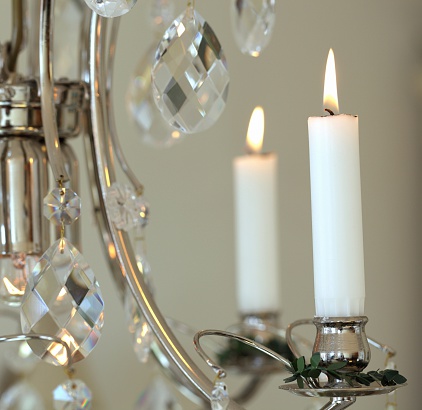 Electric candles on a chandelier with tassels