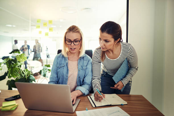 istock Two businesswomen working online and writing notes in an office 981766680
