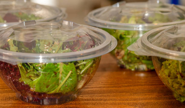 Green salad mix inside transparent take away bowl packages. Baby spinach, arugula, lettuce, rocket, romaine in disposable plastic packaging, healthy food restaurant delivery concept multiple portion. mezcla de ensalada verde interior transparente llevar paquetes del tazón de fuente. espinaca, rúcula, lechuga, cohete, romaine en envases de plástico desechables, concepto de entrega de restaurante de comida saludable del bebé parte múltiples.