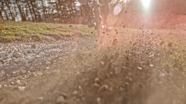 SPEED RAMP Mountain biker splashing gravel into the camera in sunshine