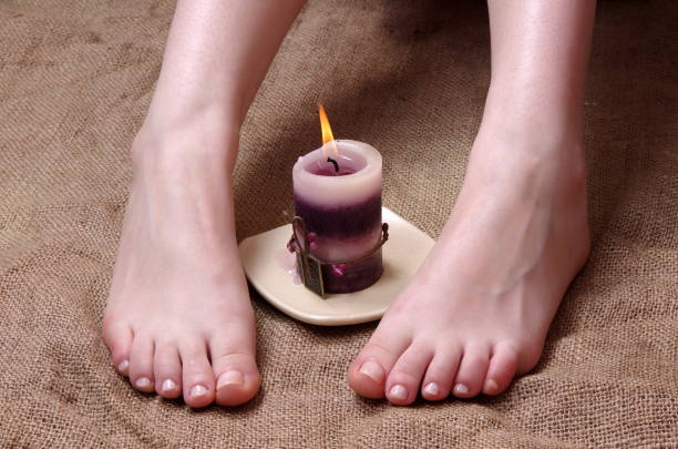 istock Low Section Of Woman With Lit Tea Light Candle On Burlap 981769850