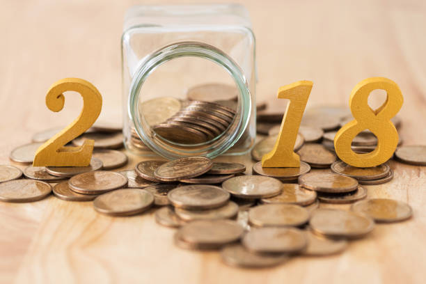 istock Close-Up Of Jar With Coins Amidst 2018 On Table 981770314