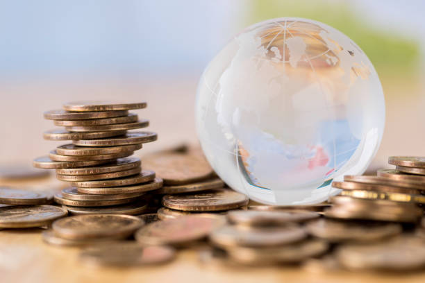 istock Close-Up Of Glass Globe On Coins At Table 981770342